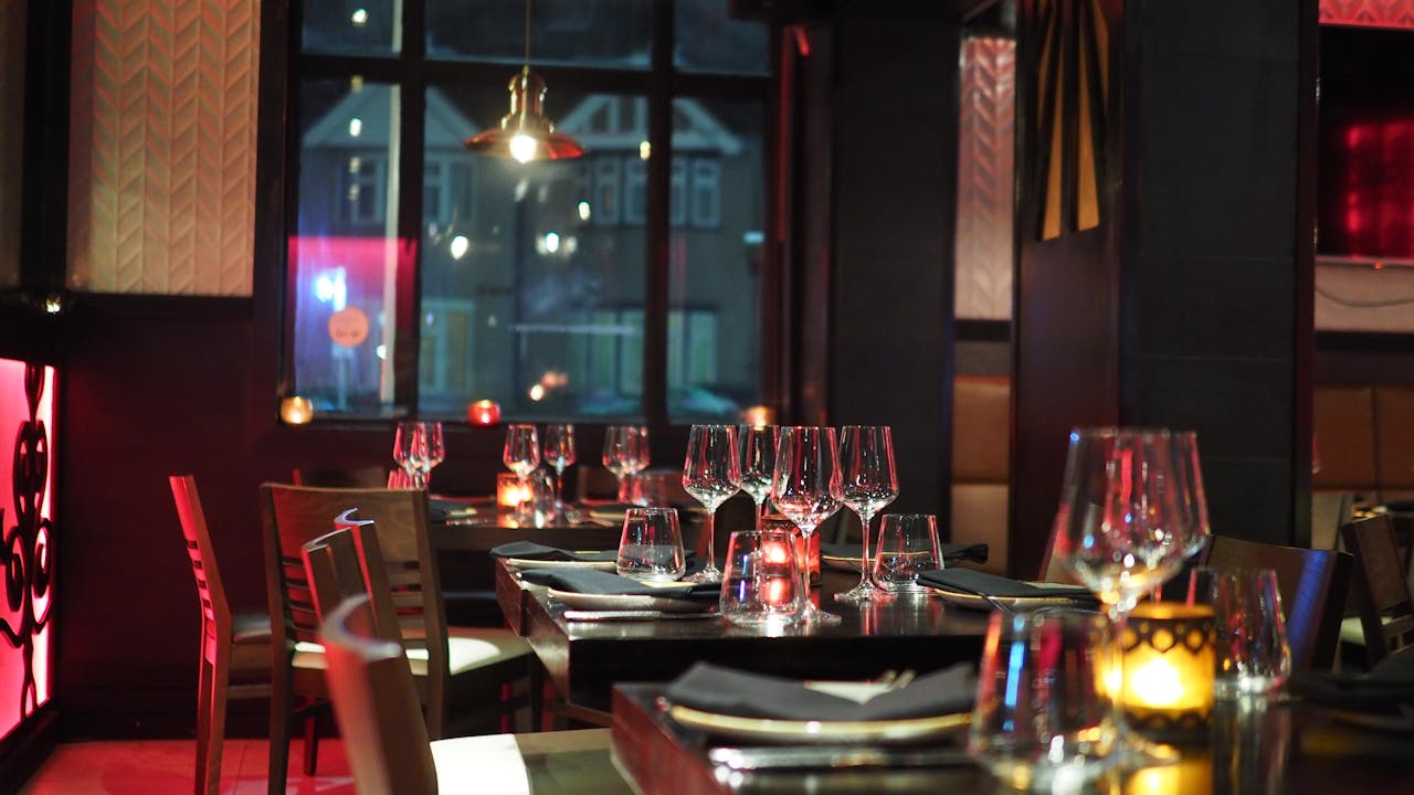A sophisticated restaurant interior with elegant table setting and ambient candlelight, creating a cozy atmosphere.